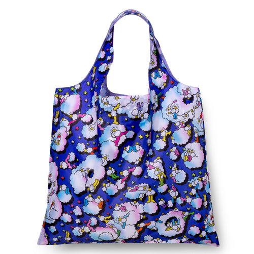 A reusable tote bag featuring a vibrant cartoon pattern of puffy pastel clouds and small characters on a deep blue background, shown against a plain white studio backdrop.