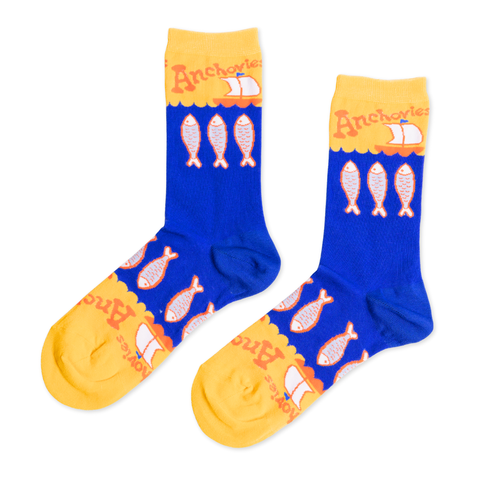 Blue and yellow crew socks featuring illustrated anchovies and Anchovies text with sailboat by Yellow Owl Workshop