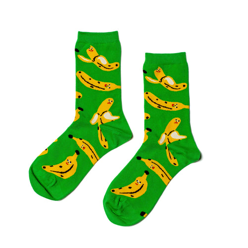 Bright green crew socks featuring playful illustrated banana characters by Kristina Micotti for Yellow Owl Workshop