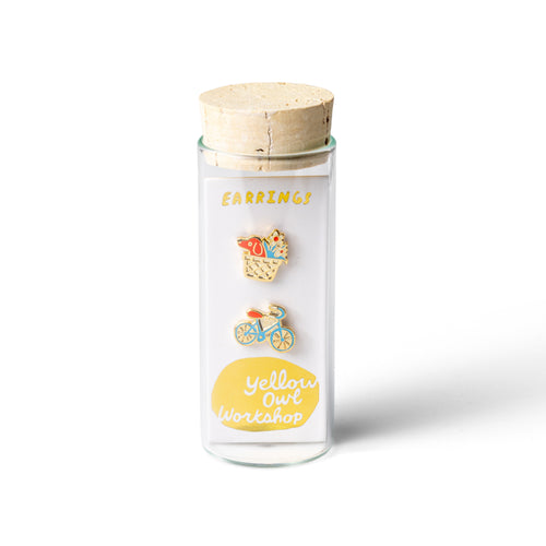 Mismatched bike and basket earrings featuring a bicycle design and a basket with a dog and flowers, in colorful enamel with gold-toned details.