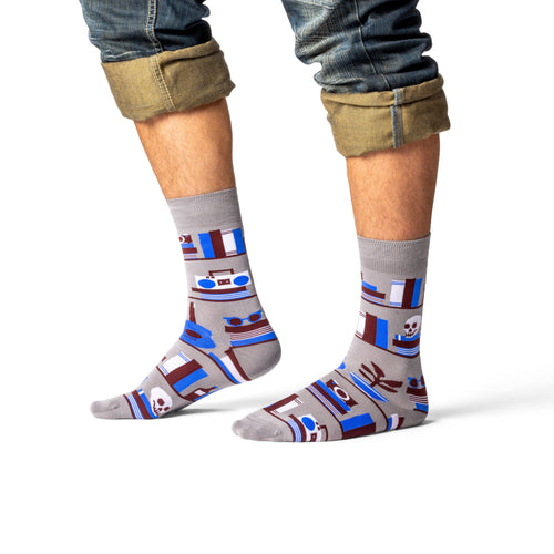 Grey bookshelf crew socks with illustrated books and skull worn on leg side view by Yellow Owl Workshop