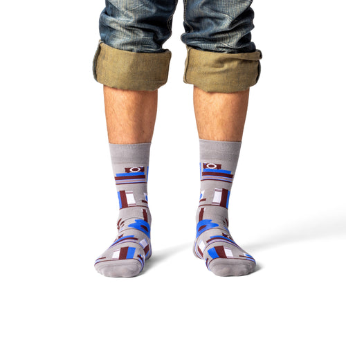 Grey bookshelf crew socks with illustrated books and skull worn on leg straight on by Yellow Owl Workshop
