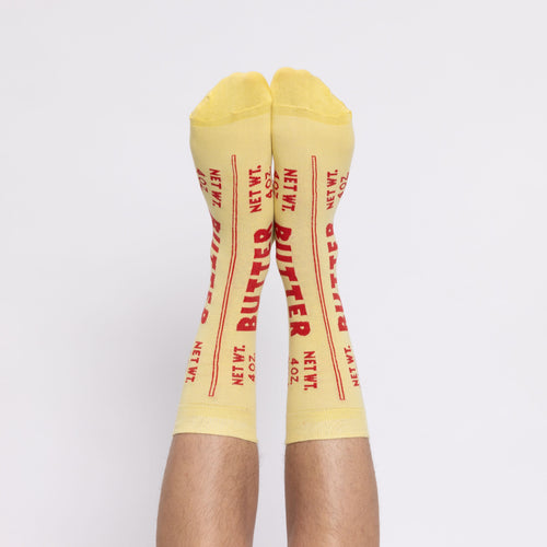 Yellow Butter crew socks with bold red label worn on feet by Yellow Owl Workshop