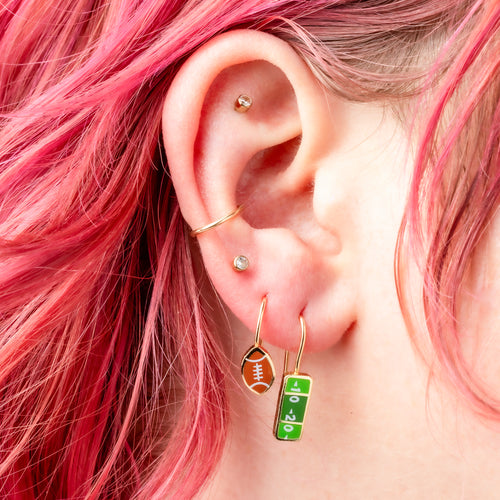 Football Fans mismatched enamel drop earrings worn on ear by Yellow Owl Workshop