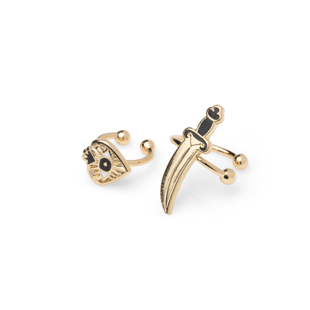 Mismatched gold all-seeing eye heart and dagger no-piercing ear cuffs with black enamel detail by Yellow Owl Workshop