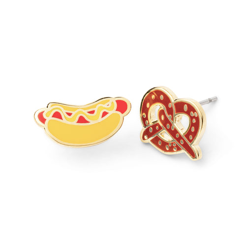 Mismatched cloisonné stud earrings featuring mustard hot dog and salty pretzel gilded in 22 karat gold by Yellow Owl Workshop