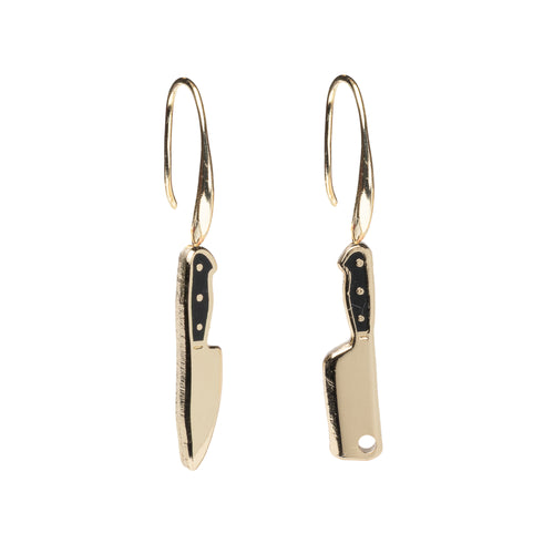 Mismatched enamel drop earrings featuring gold chef's knife and gold cleaver with black handles by Yellow Owl Workshop