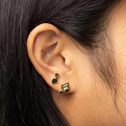 Musical notes mismatched cloisonné stud earrings worn on ear by Yellow Owl Workshop
