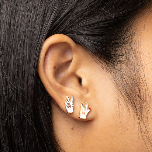 Peace and Love mismatched gold stud earrings worn on ear by Yellow Owl Workshop