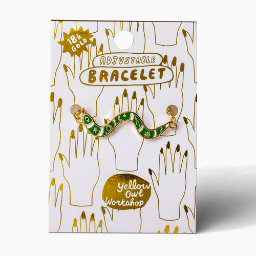 Green enamel snake charm bracelet on gold foil packaging card by Yellow Owl Workshop