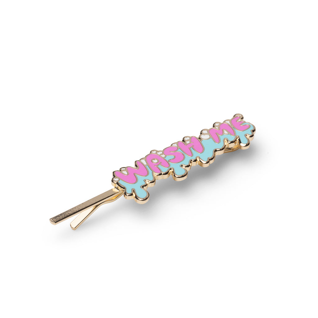 Gold cloisonné enamel Wash Me hair pin in pink bubble letters on blue dripping background by Yellow Owl Workshop