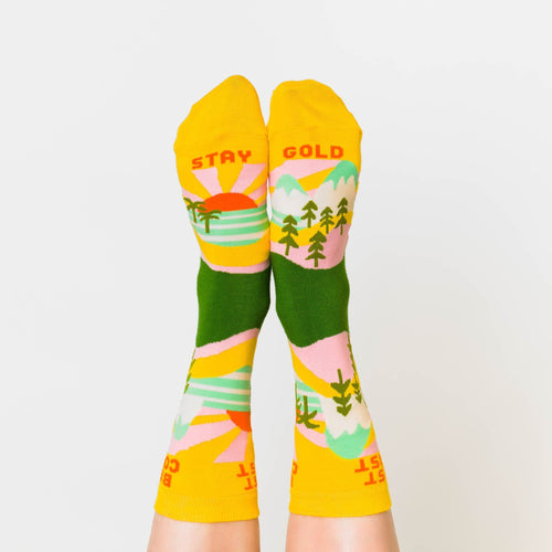 Yellow Best Coast crew socks with West Coast and Best Coast text and landscape print worn on feet by Yellow Owl Workshop