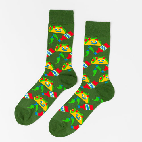 Green crew socks featuring illustrated smiling tacos hot sauce packets and green chilis by Yellow Owl Workshop